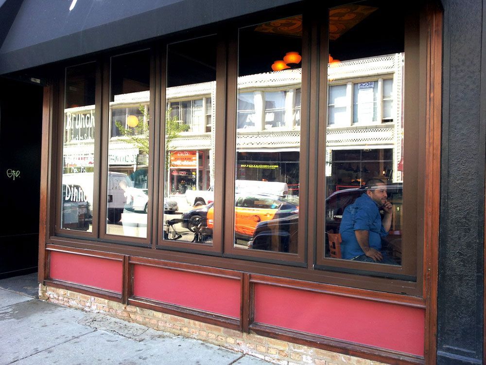A man in a blue shirt is looking out a window