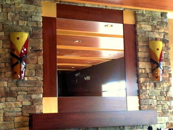 A brick wall with a mirror and two lights on it