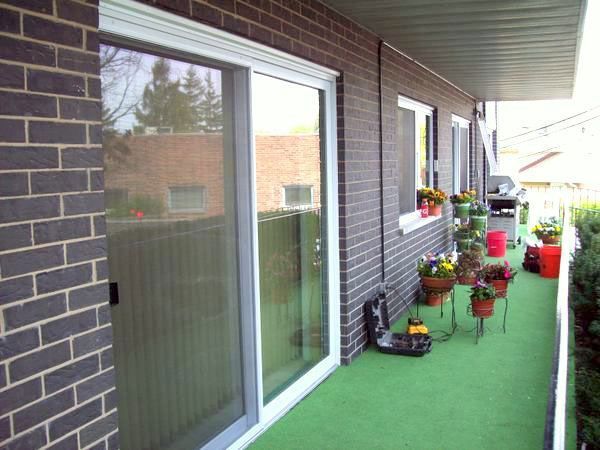 A balcony with sliding glass doors and potted plants