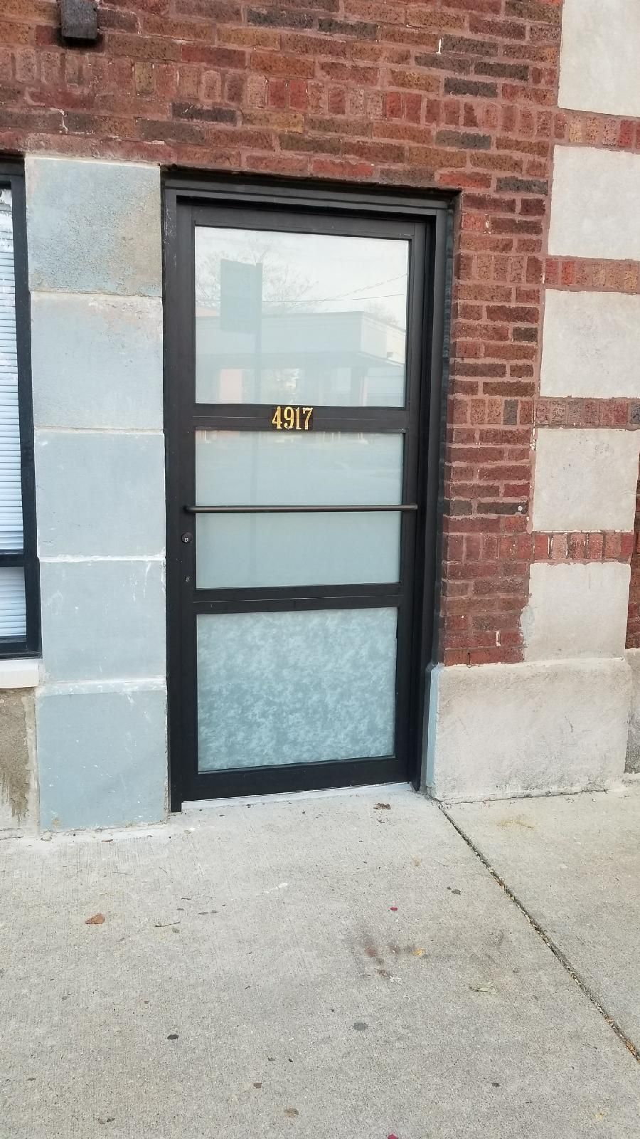 A brick building with a black door and a window.