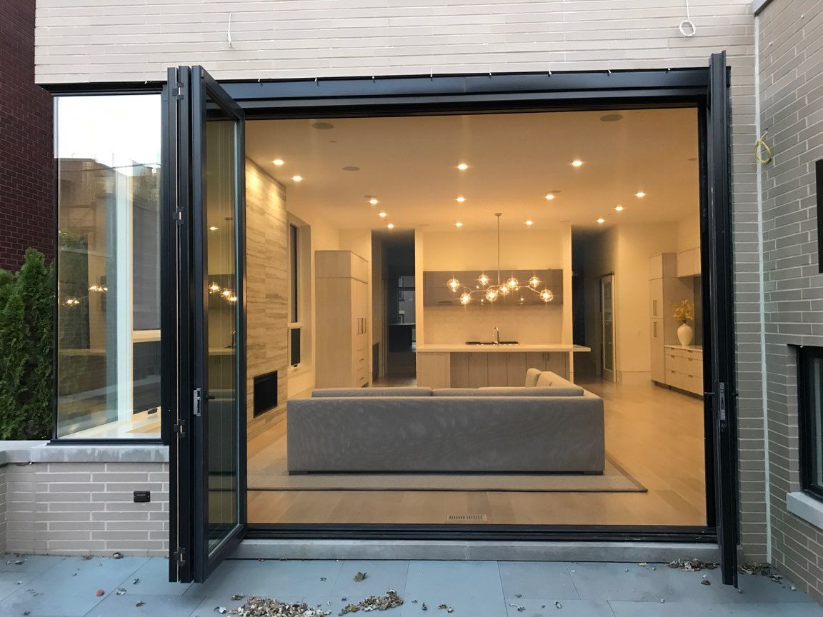 A sliding glass door open to a living room and kitchen