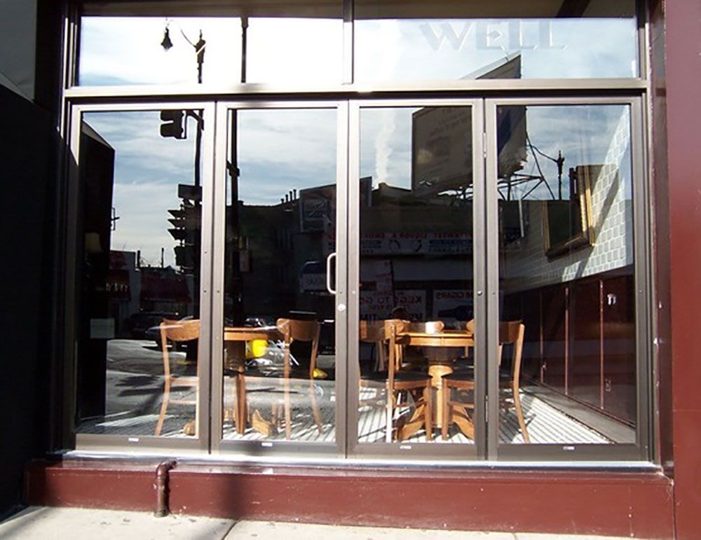 A store front with tables and chairs and a sign that says well