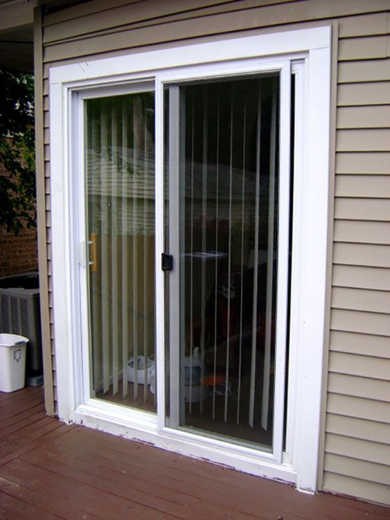 A sliding glass door with vertical blinds on a house