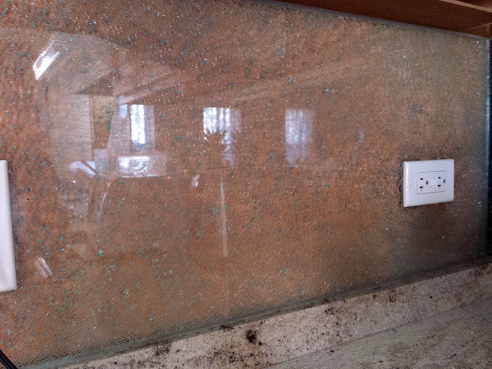 A dirty glass wall with a few electrical outlets on it.