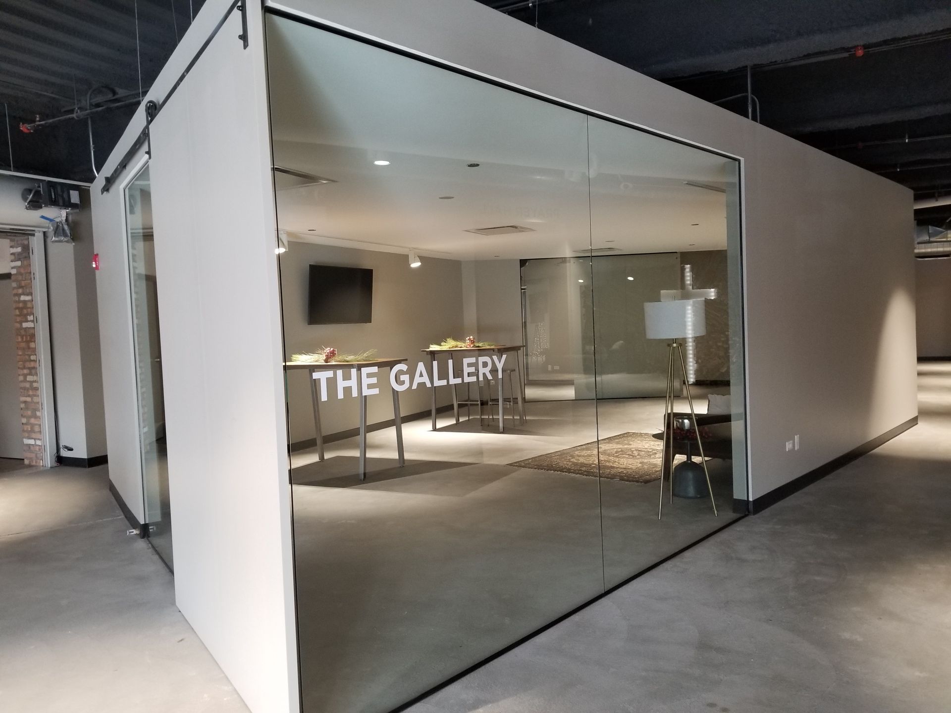 A room with a glass wall and a sign that says the gallery