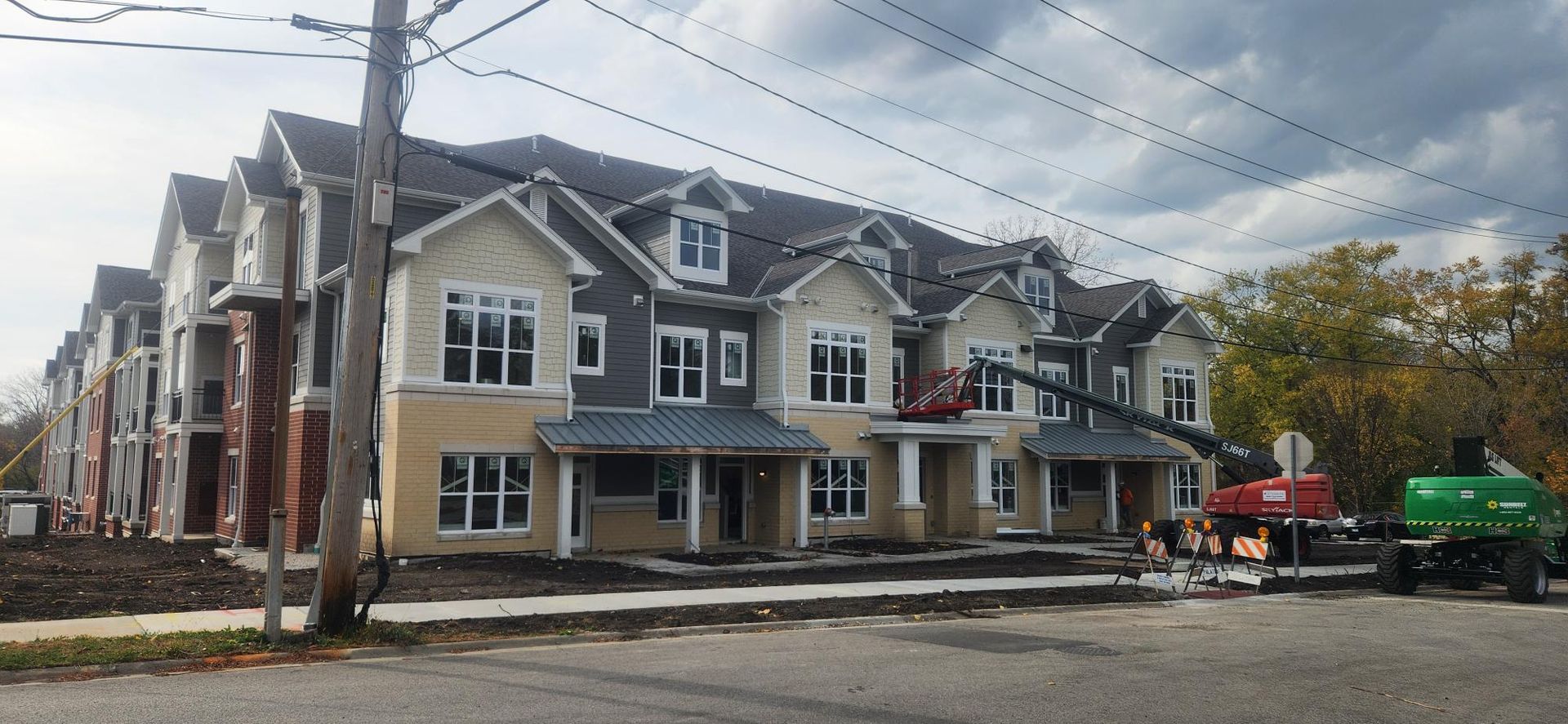 A large apartment building is being built on a cloudy day.