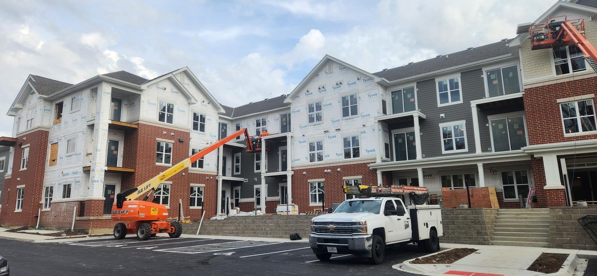 A large apartment building under construction with a truck parked in front of it.