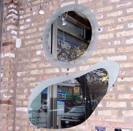 A brick wall with two mirrors and a sign that says ' ariel ' on it