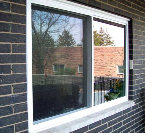 A window on a brick wall with a white frame