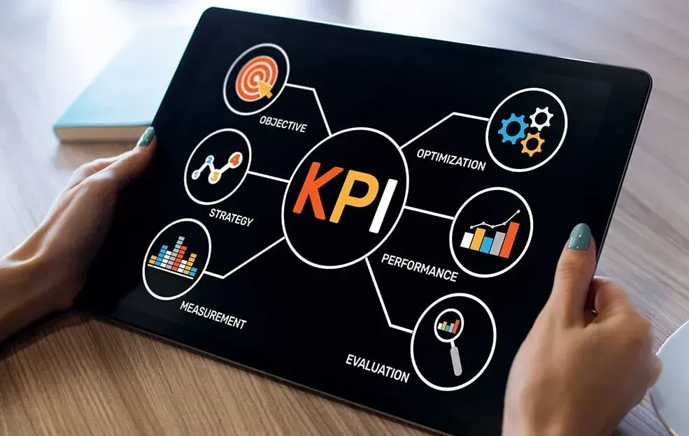 A person is holding a tablet with a diagram on it that says kpi.