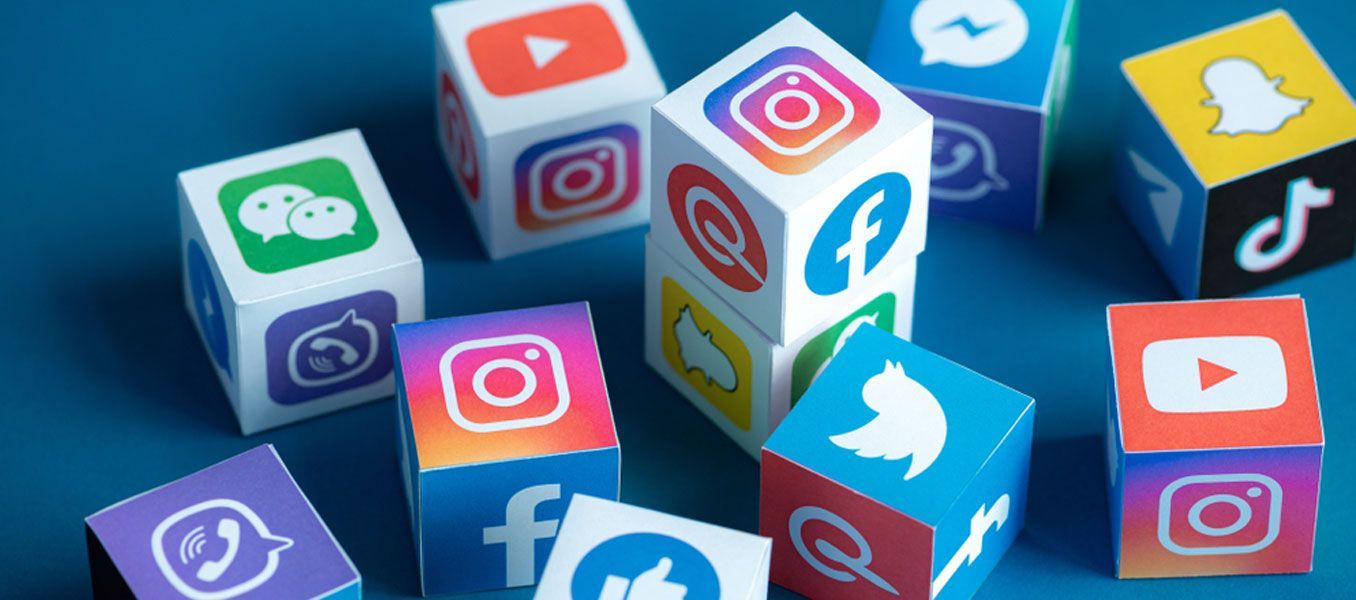 A bunch of cubes with social media icons on them on a blue background.