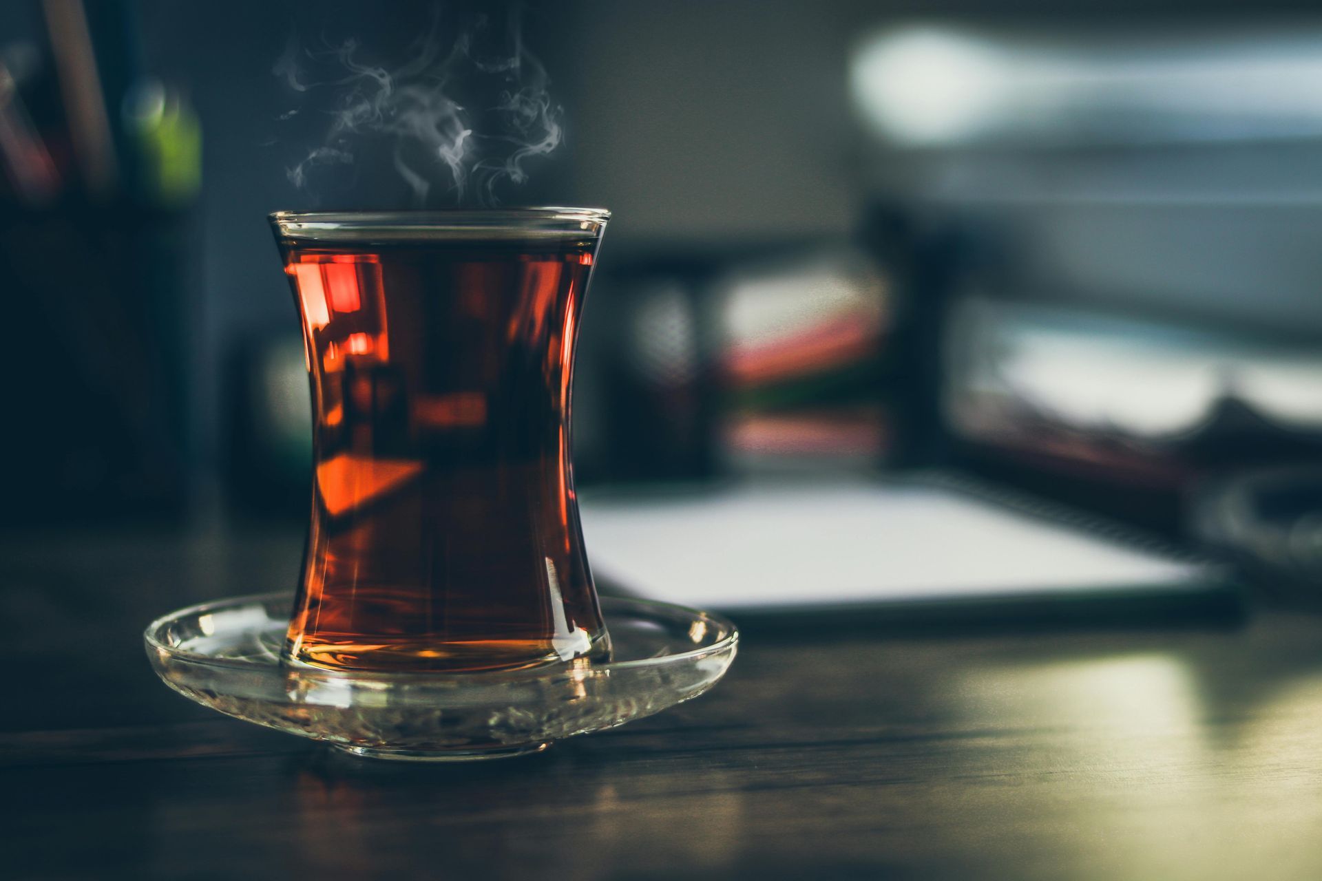 A cup of tea is sitting on a saucer on a table.