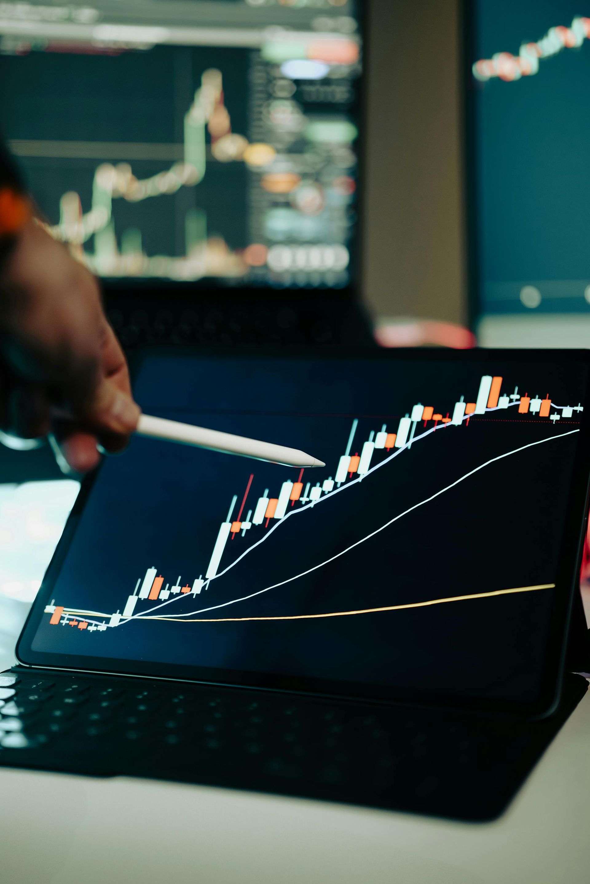A person is pointing at a graph on a tablet with a pencil.