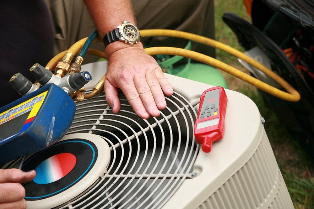 Technician Working On An Air Conditioning Unit
