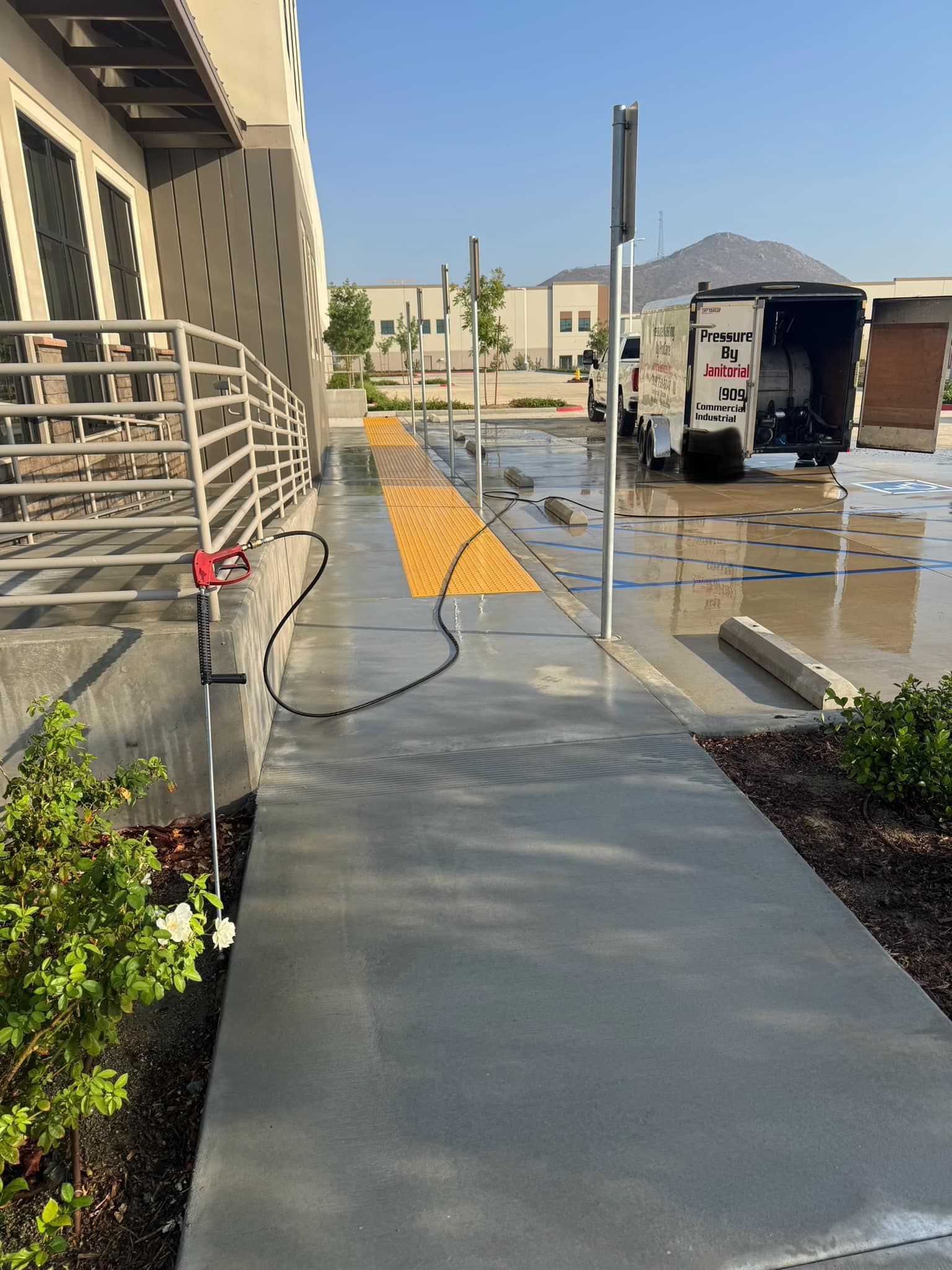 A white truck is parked on the side of the road next to a sidewalk.