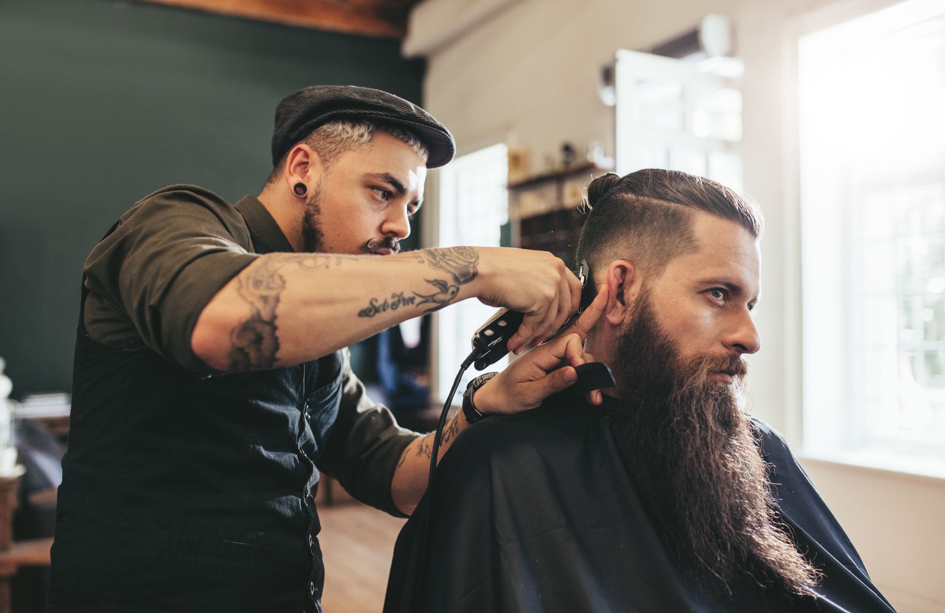 A man is getting his hair cut by a barber in a barber shop.
