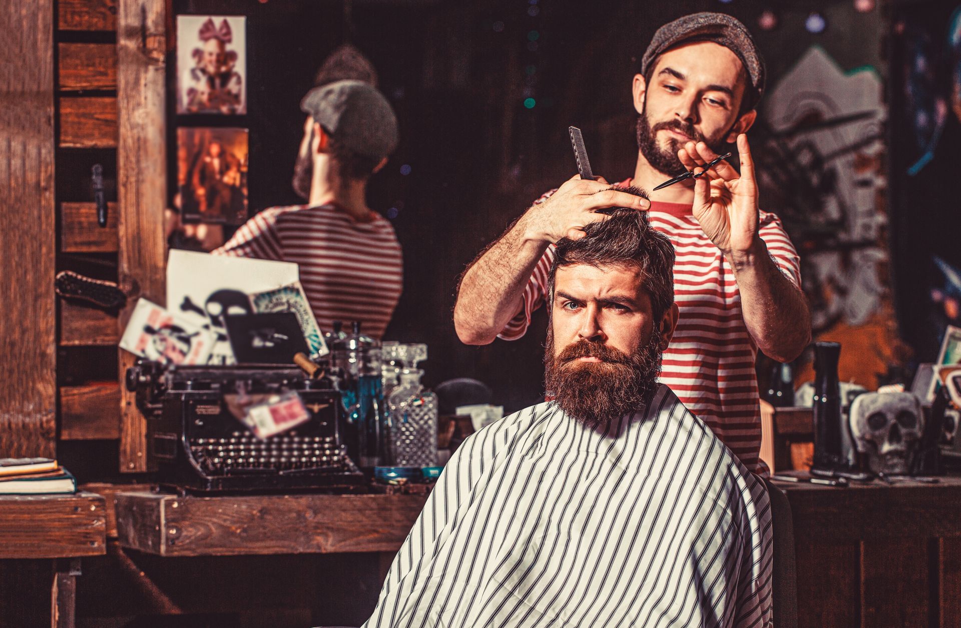 A man is getting his hair cut by a barber in a barber shop.