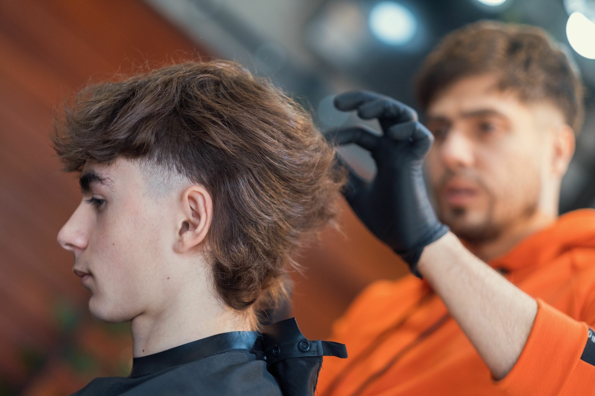 A man is getting his hair cut by a barber in a barber shop.