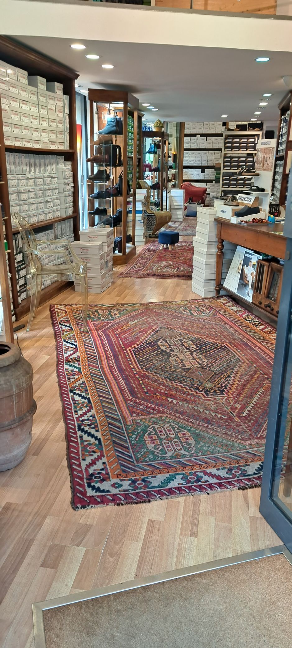 Interno di un negozio pieno di tappeti e scaffali pieni di merce.