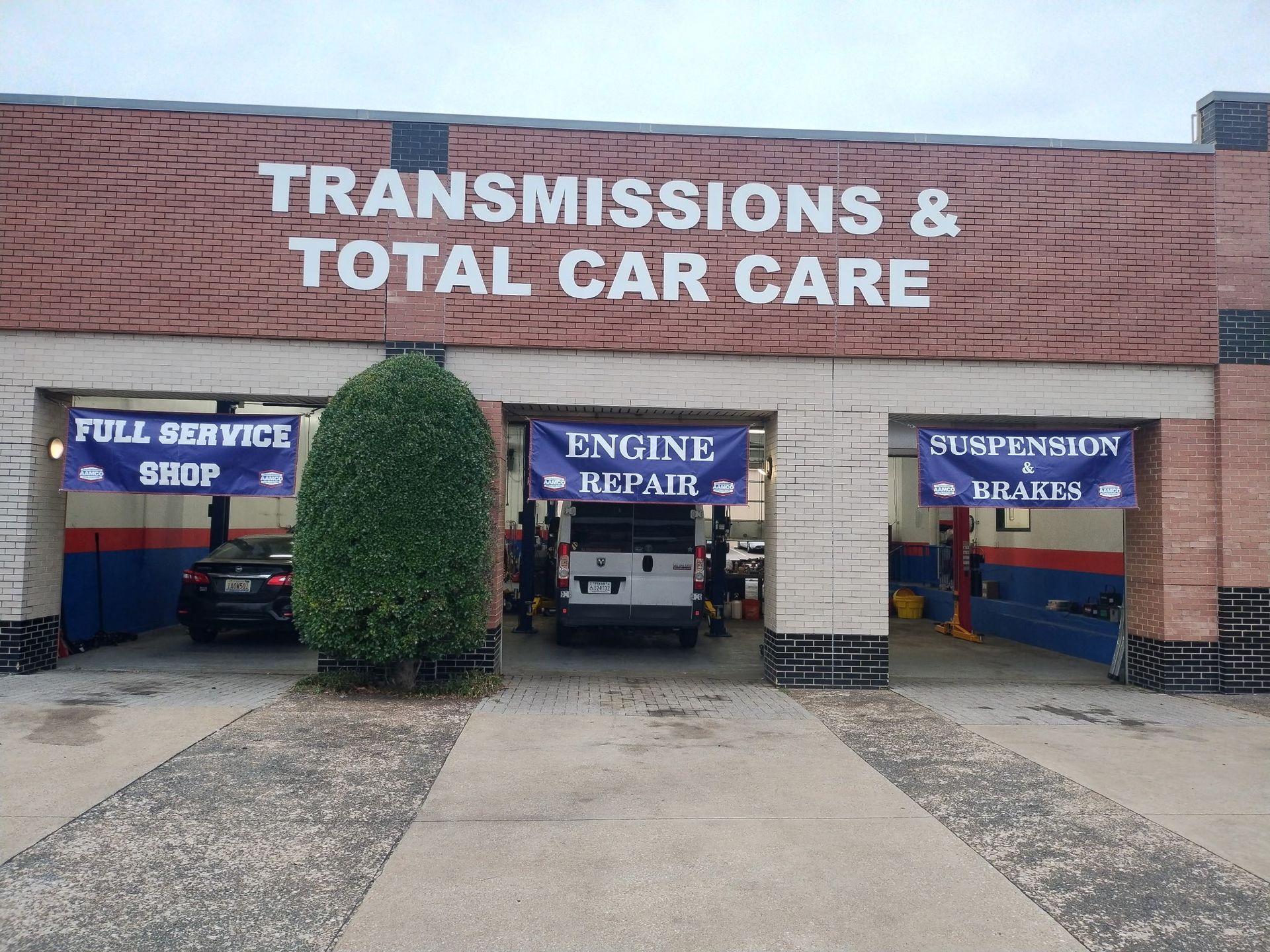 AAMCO Carrollton, TX - Transmission and auto repair shop with three open bays for fuel service, engine repair, and suspension brakes