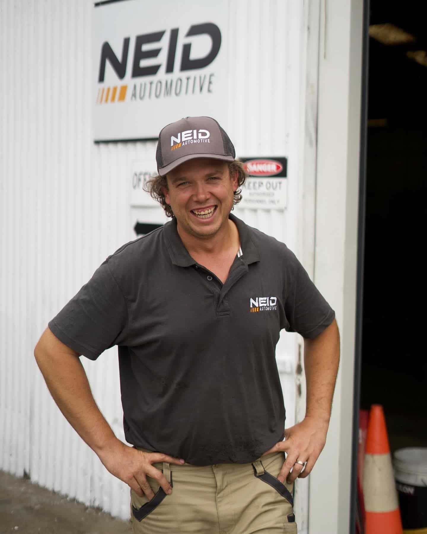A Man Standing In Front Of A Building That Says Neid Automotive — NEID Automotive In North Gosford, NSW