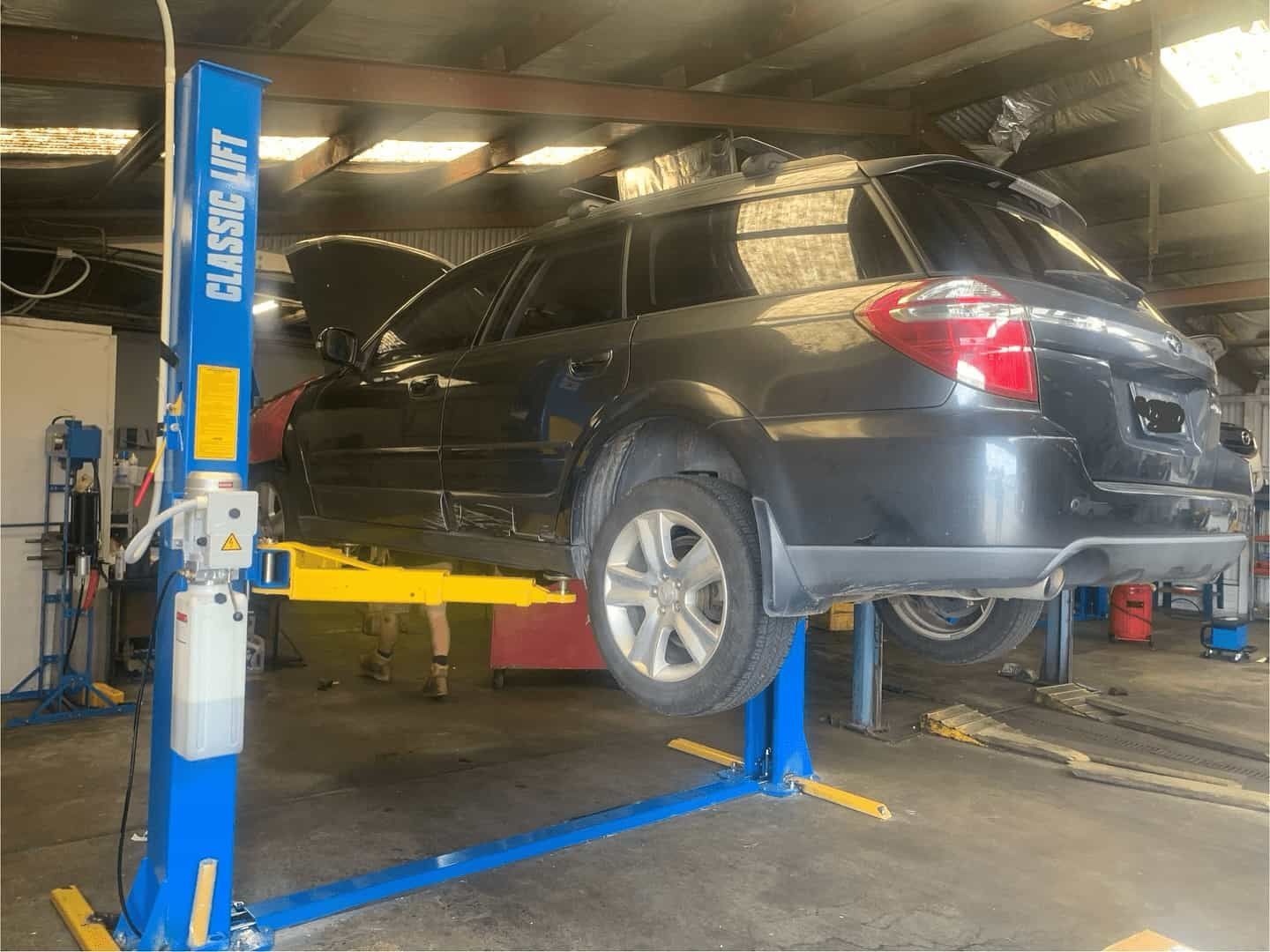 A Car Is Sitting On A Lift In A Garage — NEID Automotive In North Gosford, NSW