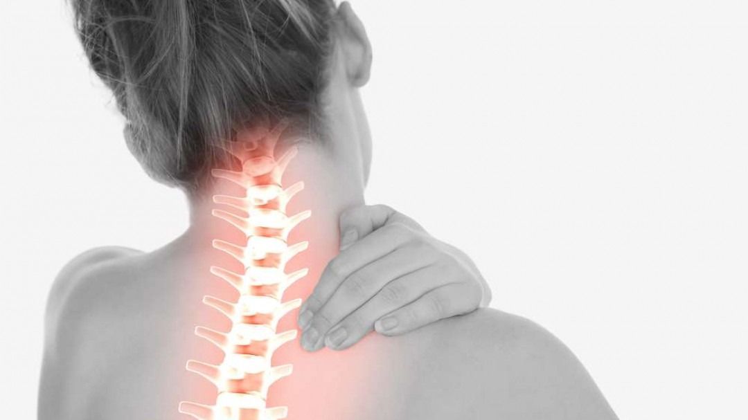 Woman holding neck, spine highlighted in red, indicating pain.