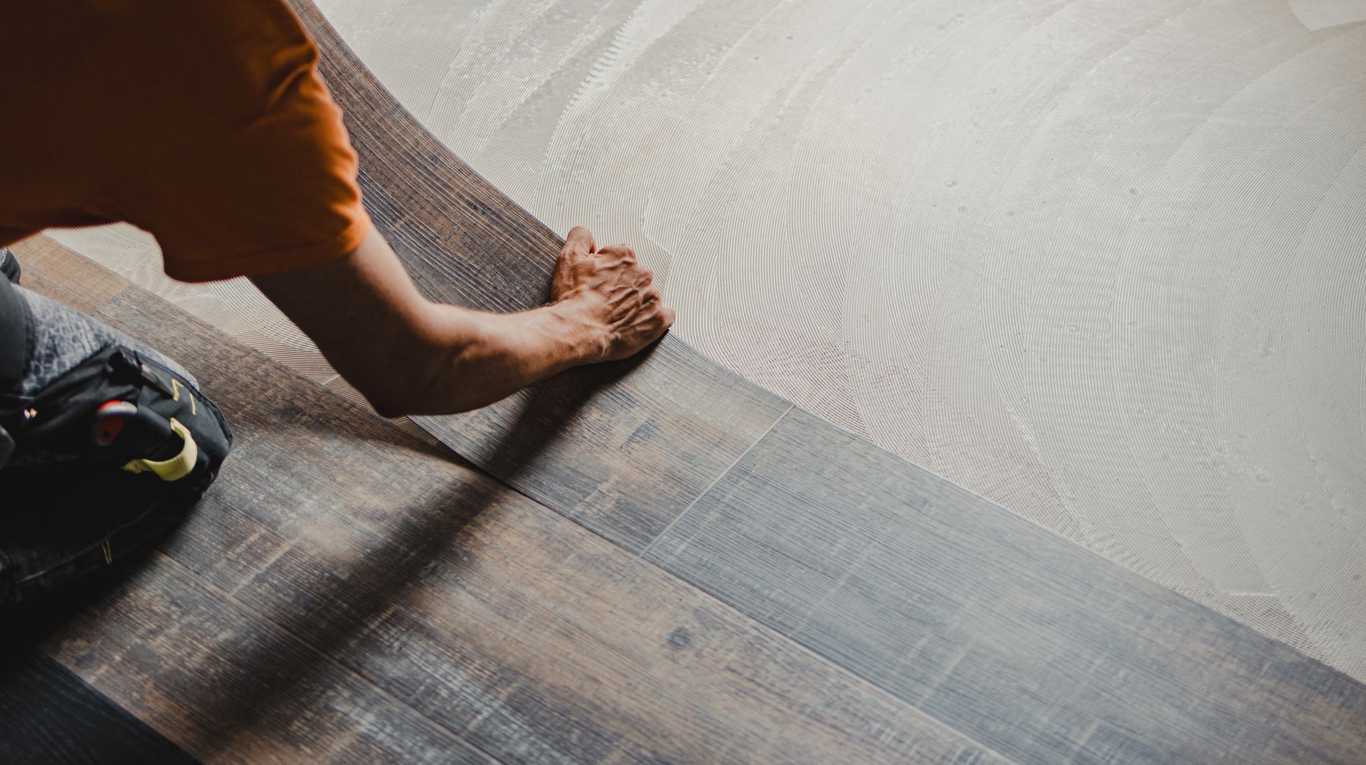 Construction worker installing luxury vinyl plank flooring. Construction worker installing luxury vinyl plank flooring.