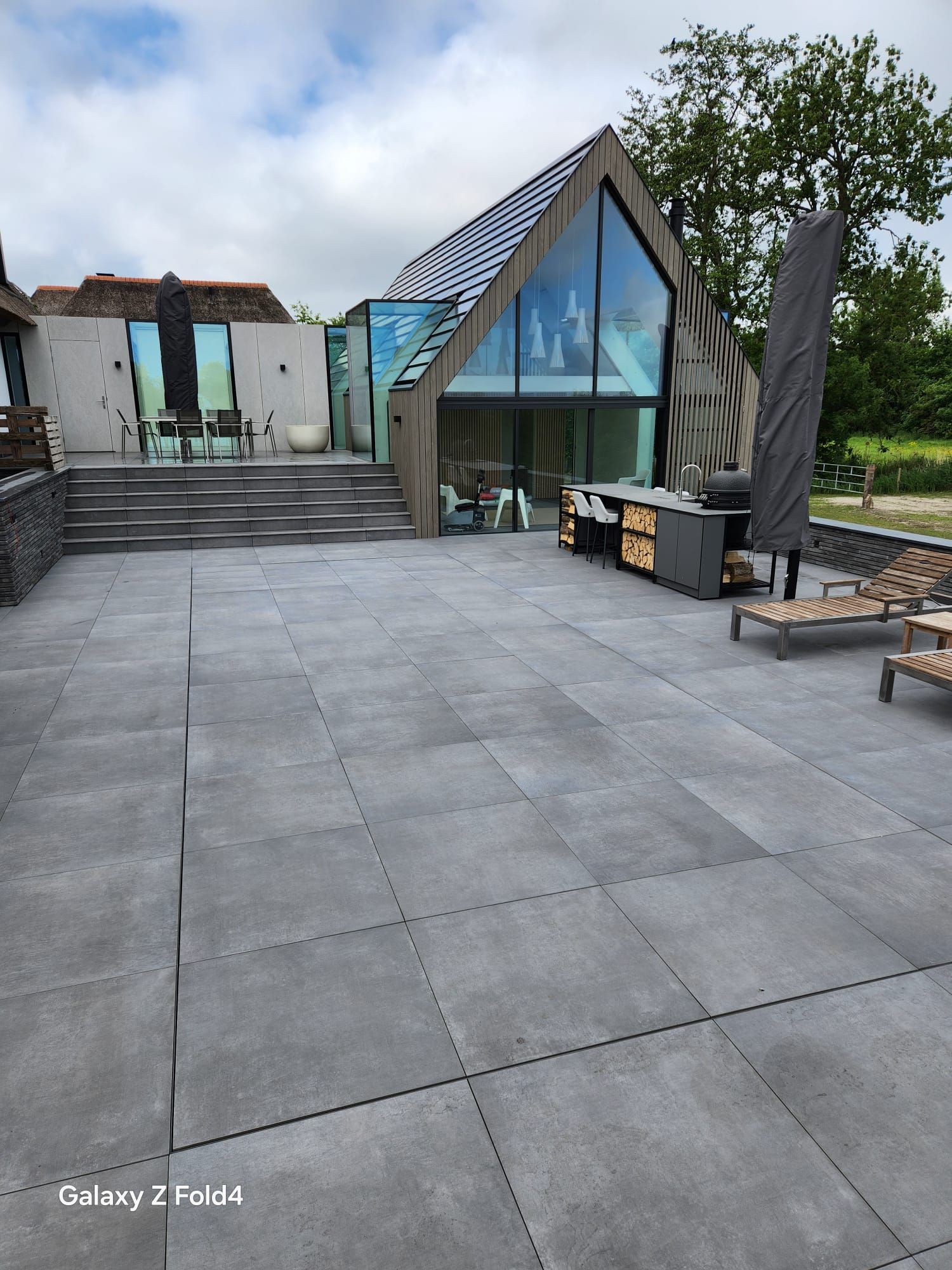 Moderne woning met groot terras en geometrische architectuur. Grijze tegels op de MagicPool