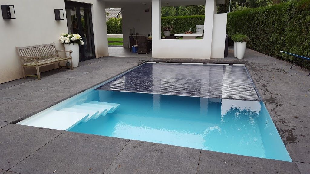 Rechthoekig zwembad (PanelPool) met witte trappen en gedeeltelijk overdekt, in een moderne achtertuin, met blauw water.