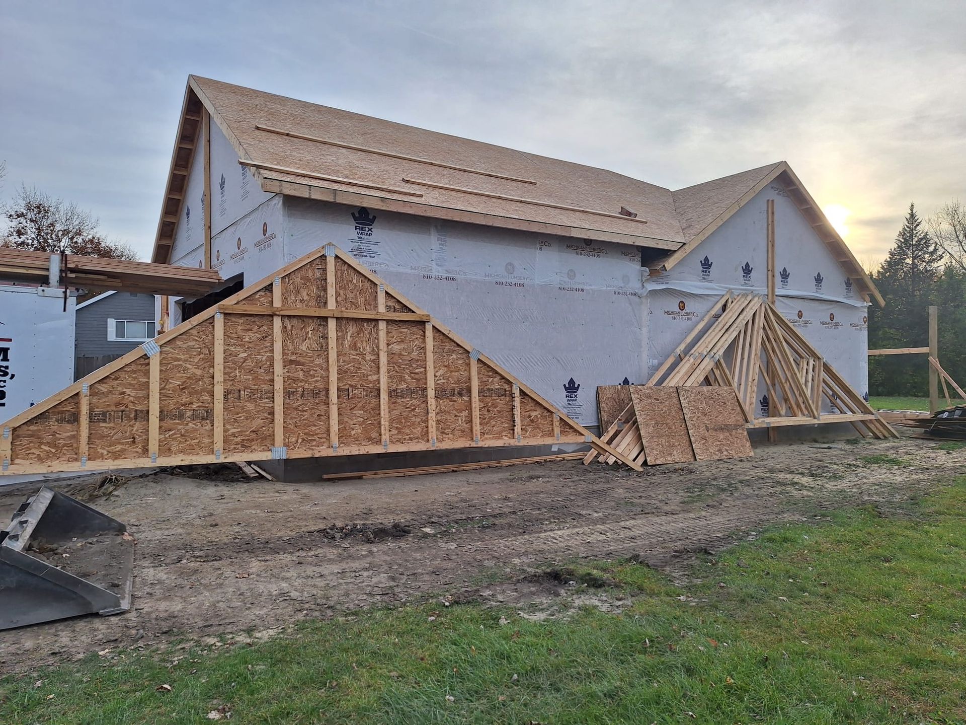 A house is being built in the middle of a grassy field.