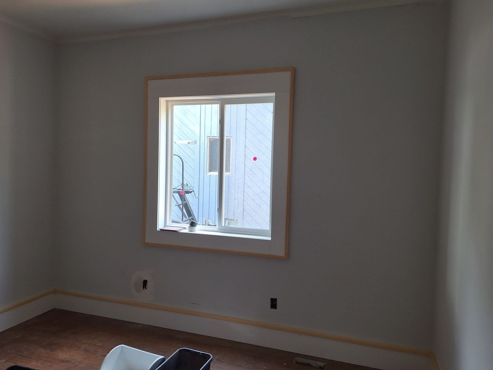 A room with a window and a chair in it