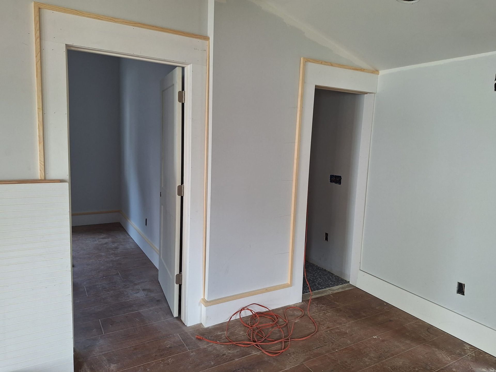 An empty room with white walls and brown carpet.