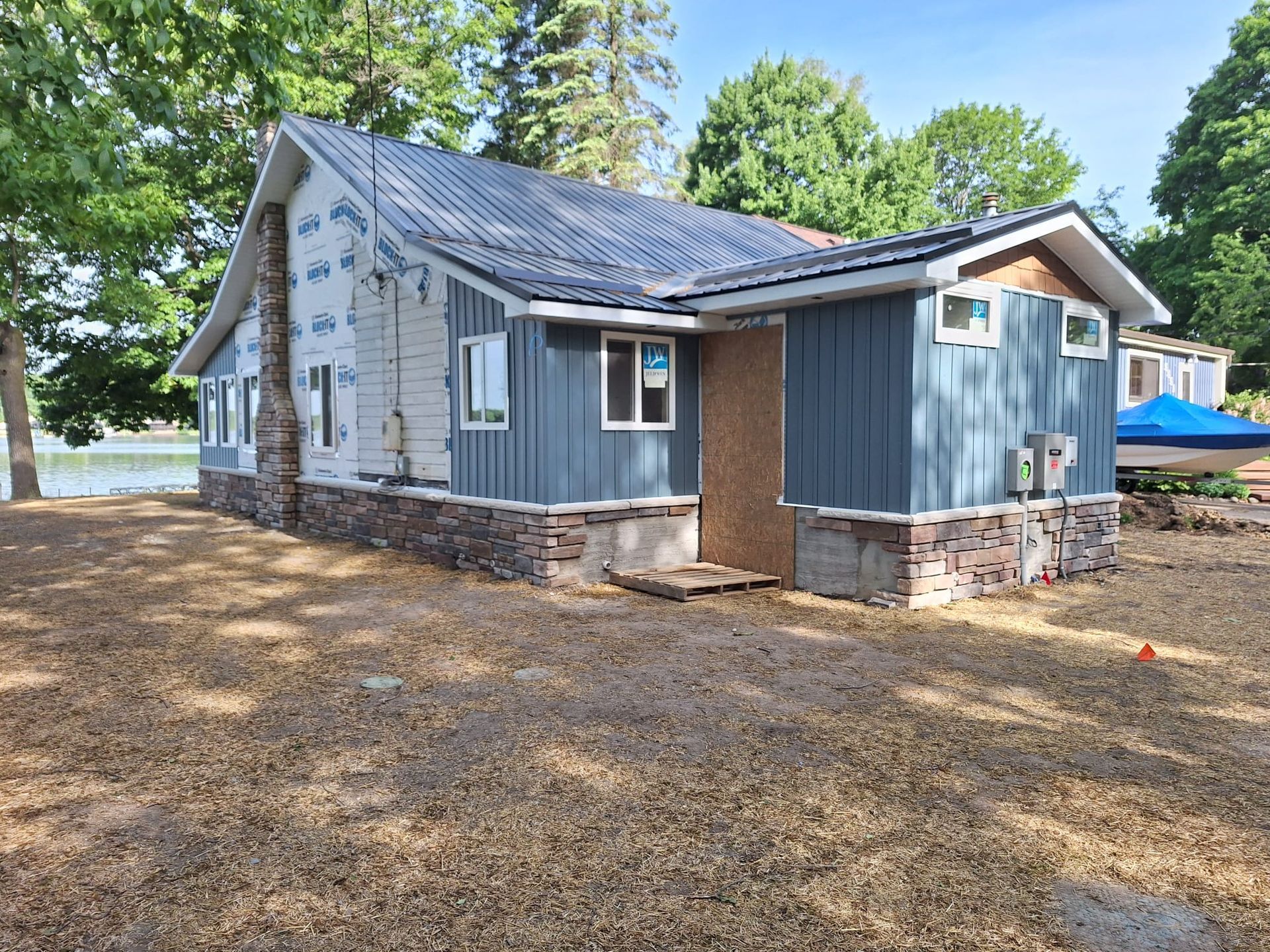 A small house is being built next to a lake.