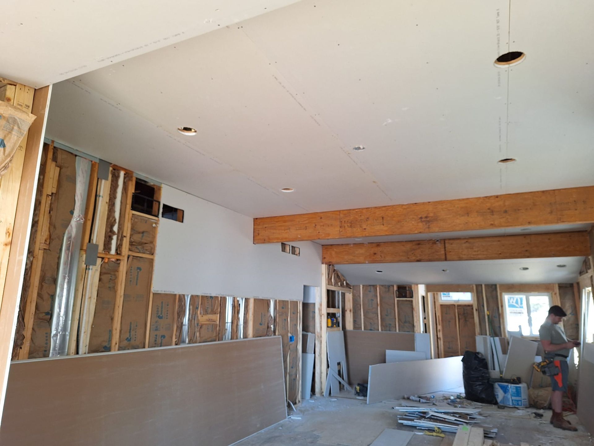 A man is standing in a room that is being remodeled.