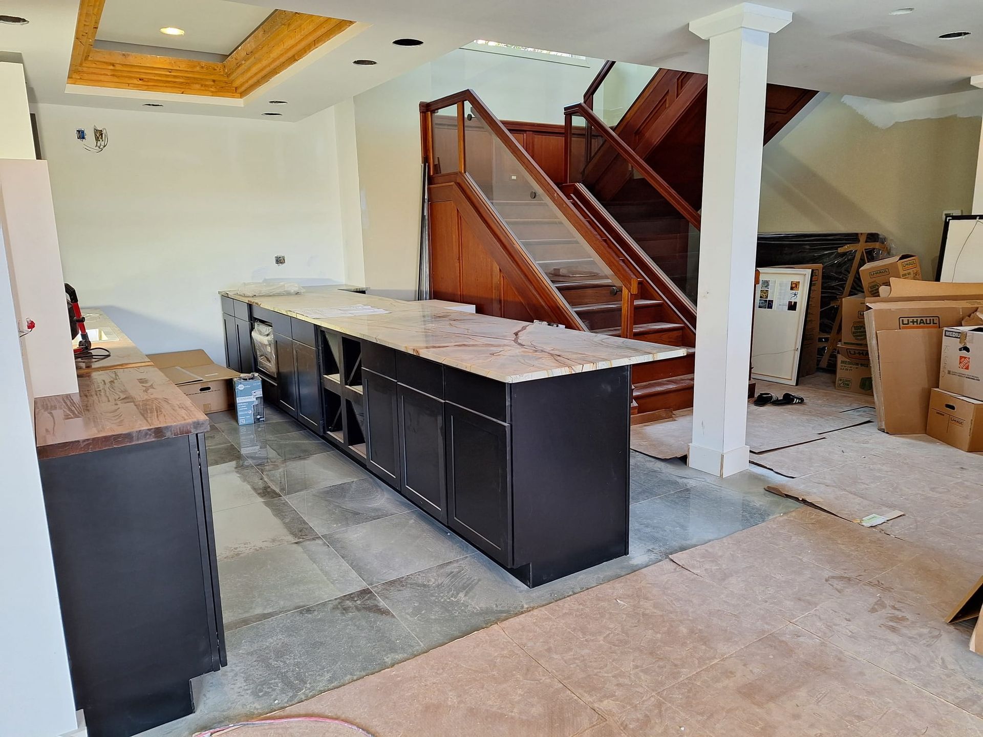 A kitchen under construction with a staircase in the background.