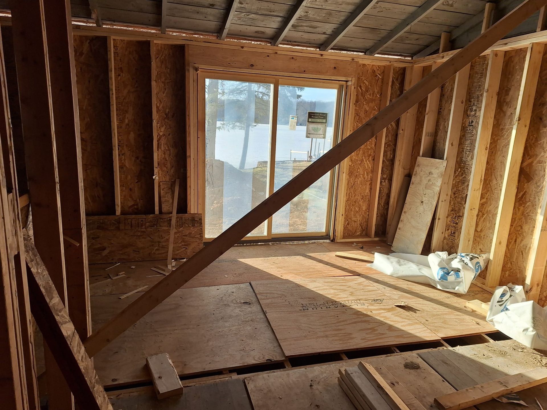 A room in a house under construction with a sliding glass door.