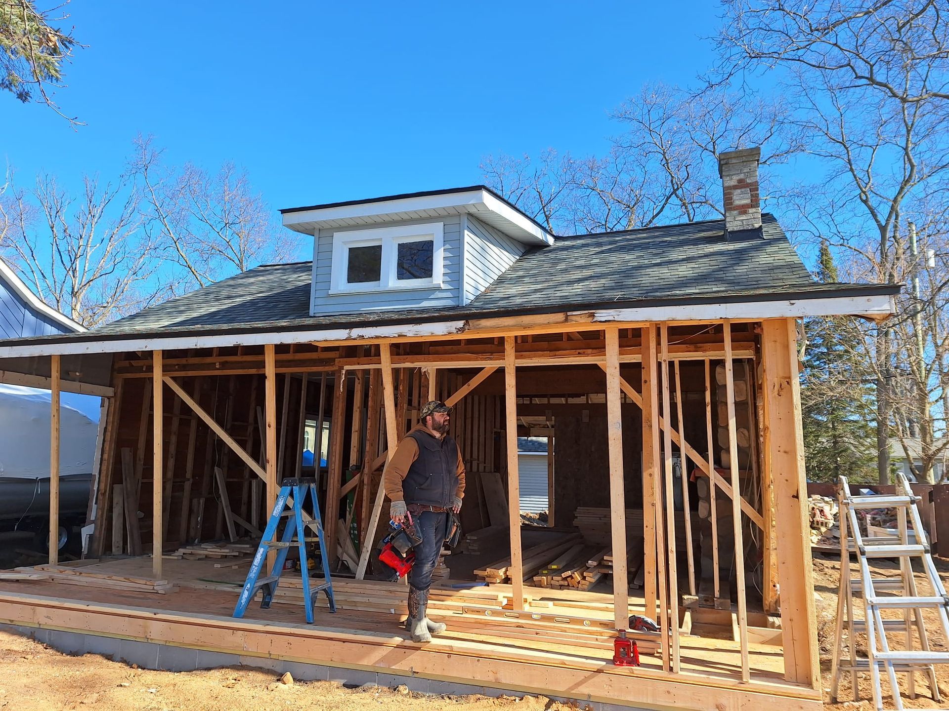 A man is standing in front of a house under construction.