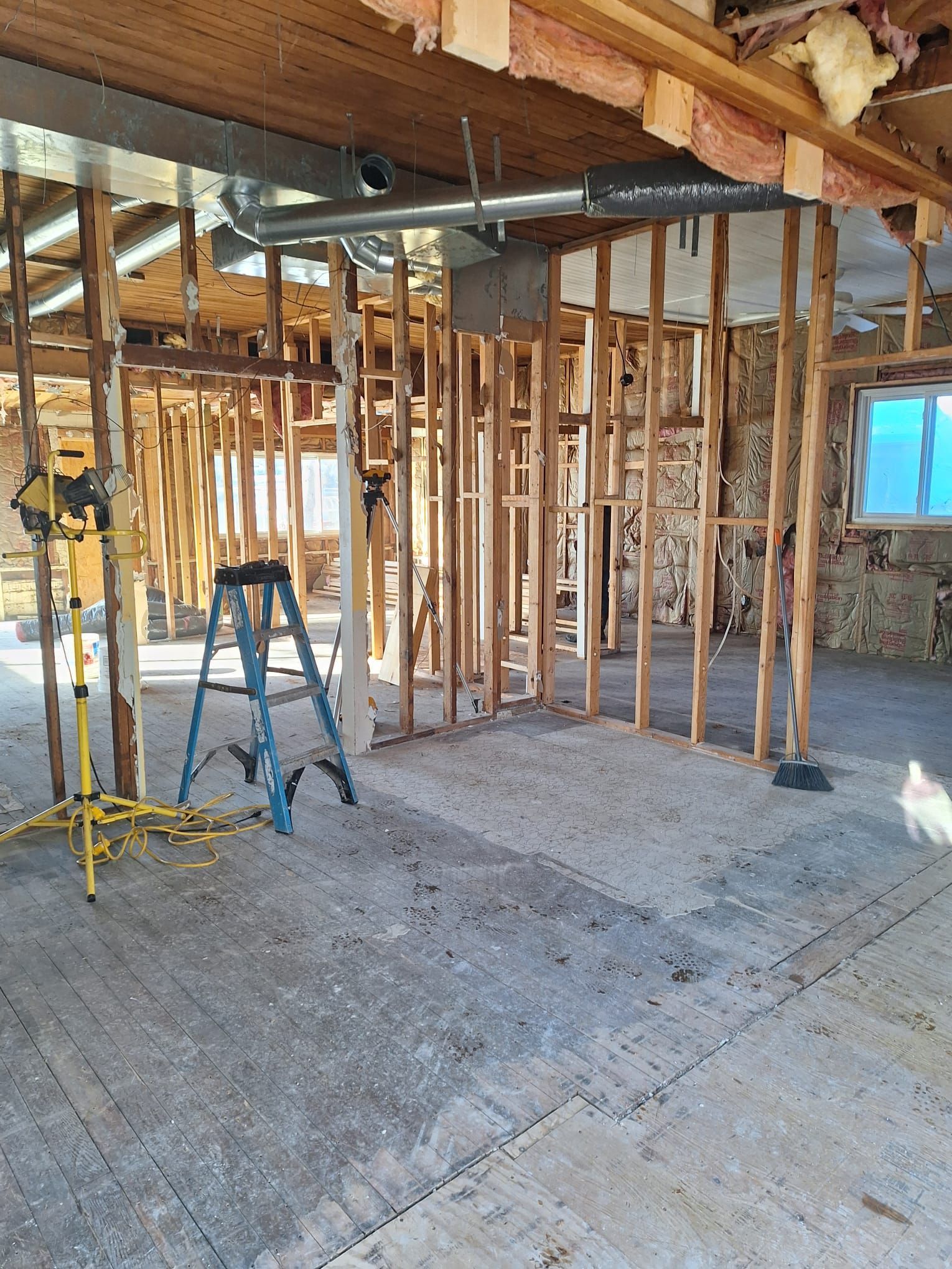 A room under construction with a ladder and a light.