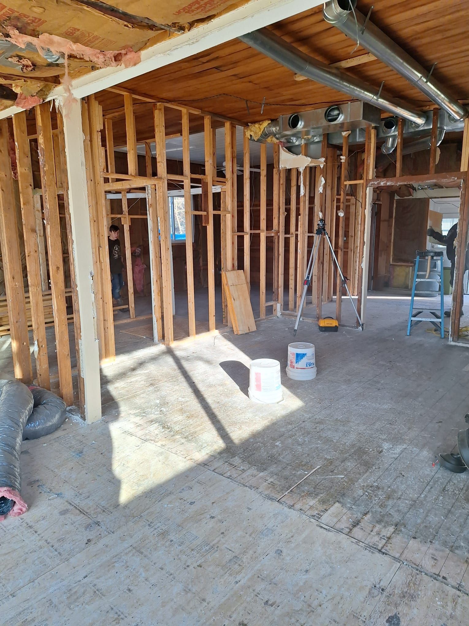 A room with a lot of wooden beams and a ladder in it.