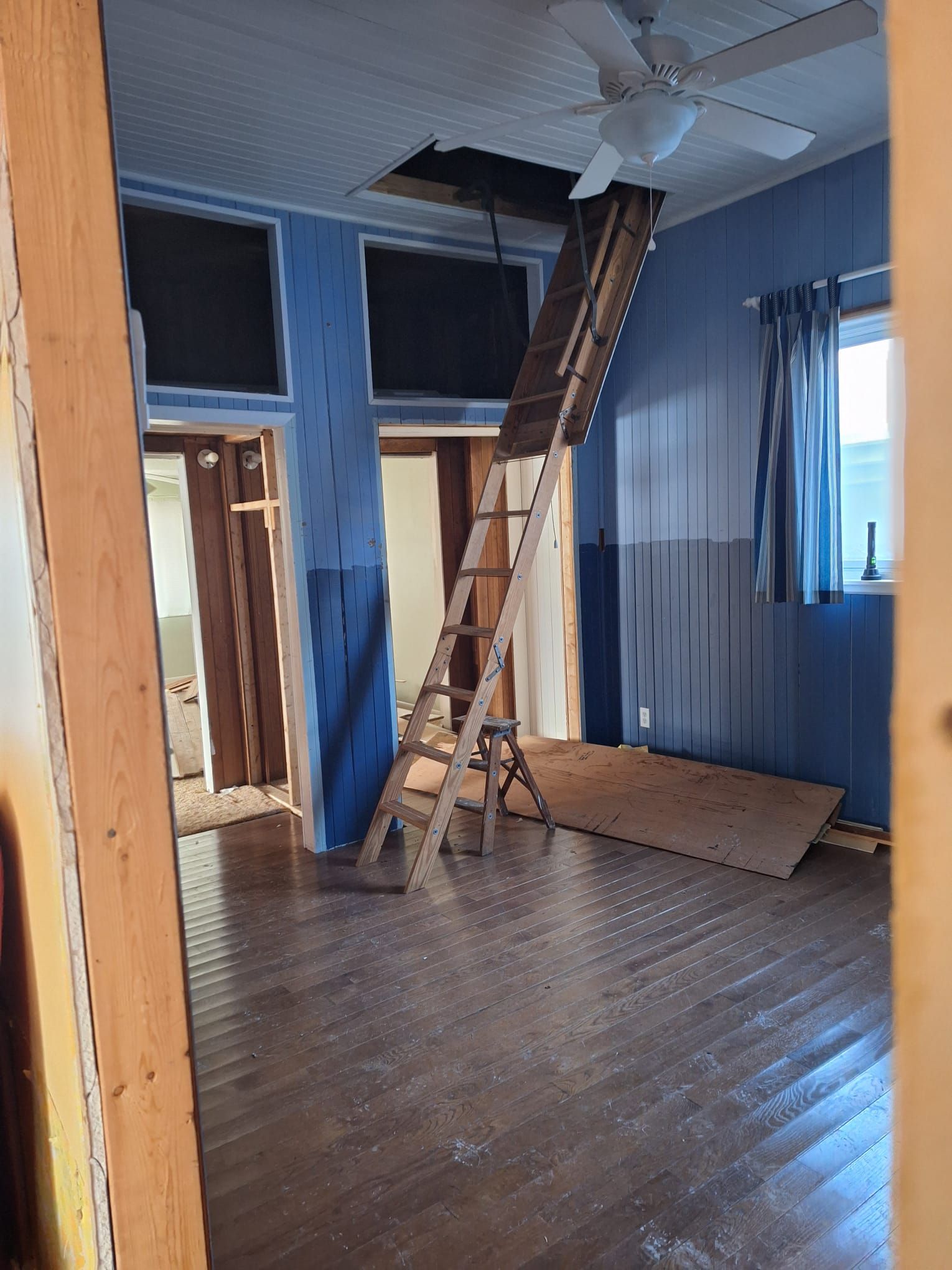 A room with a ladder going up to the second floor
