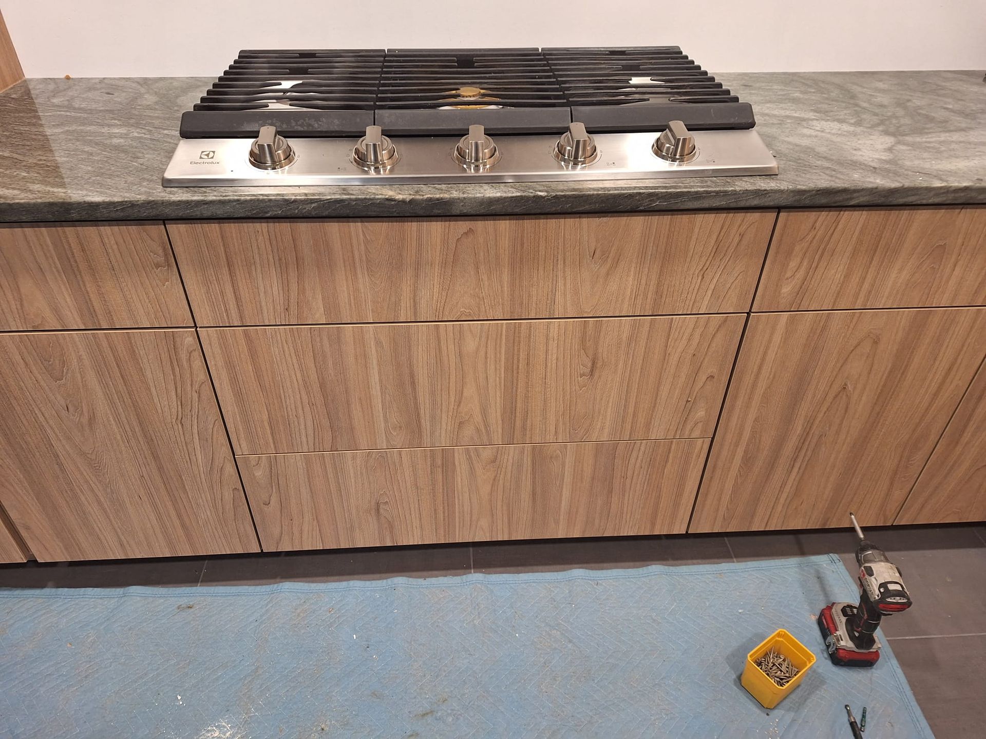 A stove top oven is being installed in a kitchen