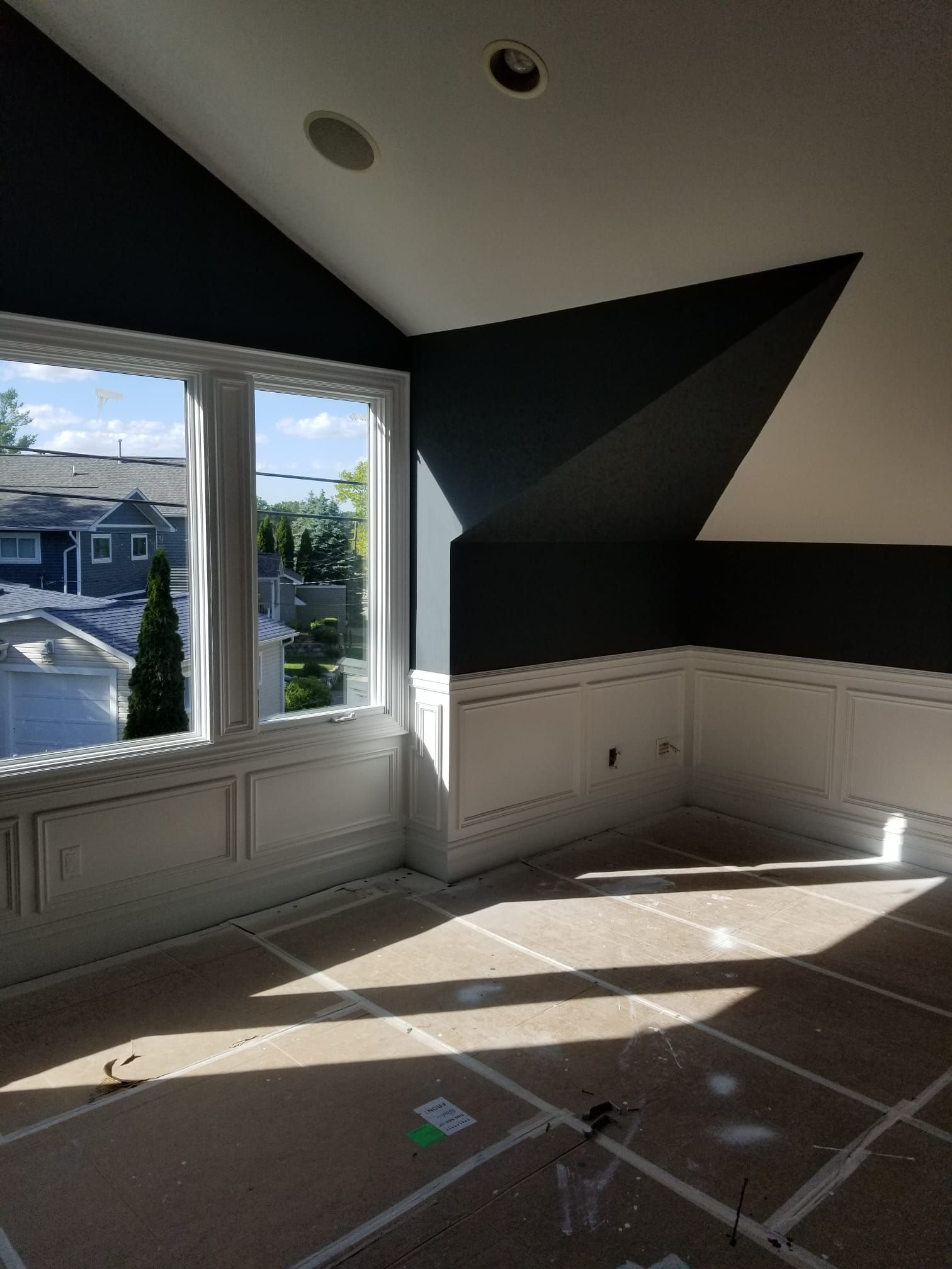 A room with a vaulted ceiling and a large window.