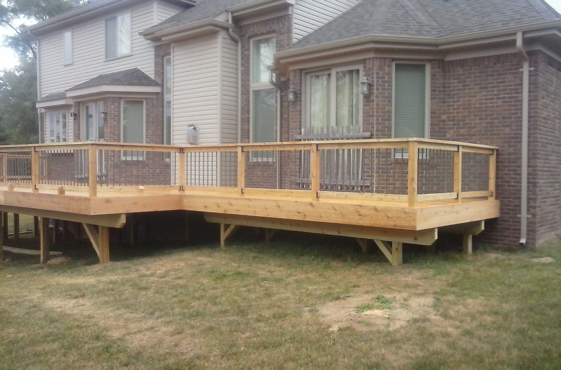 A brick house with a wooden deck in front of it