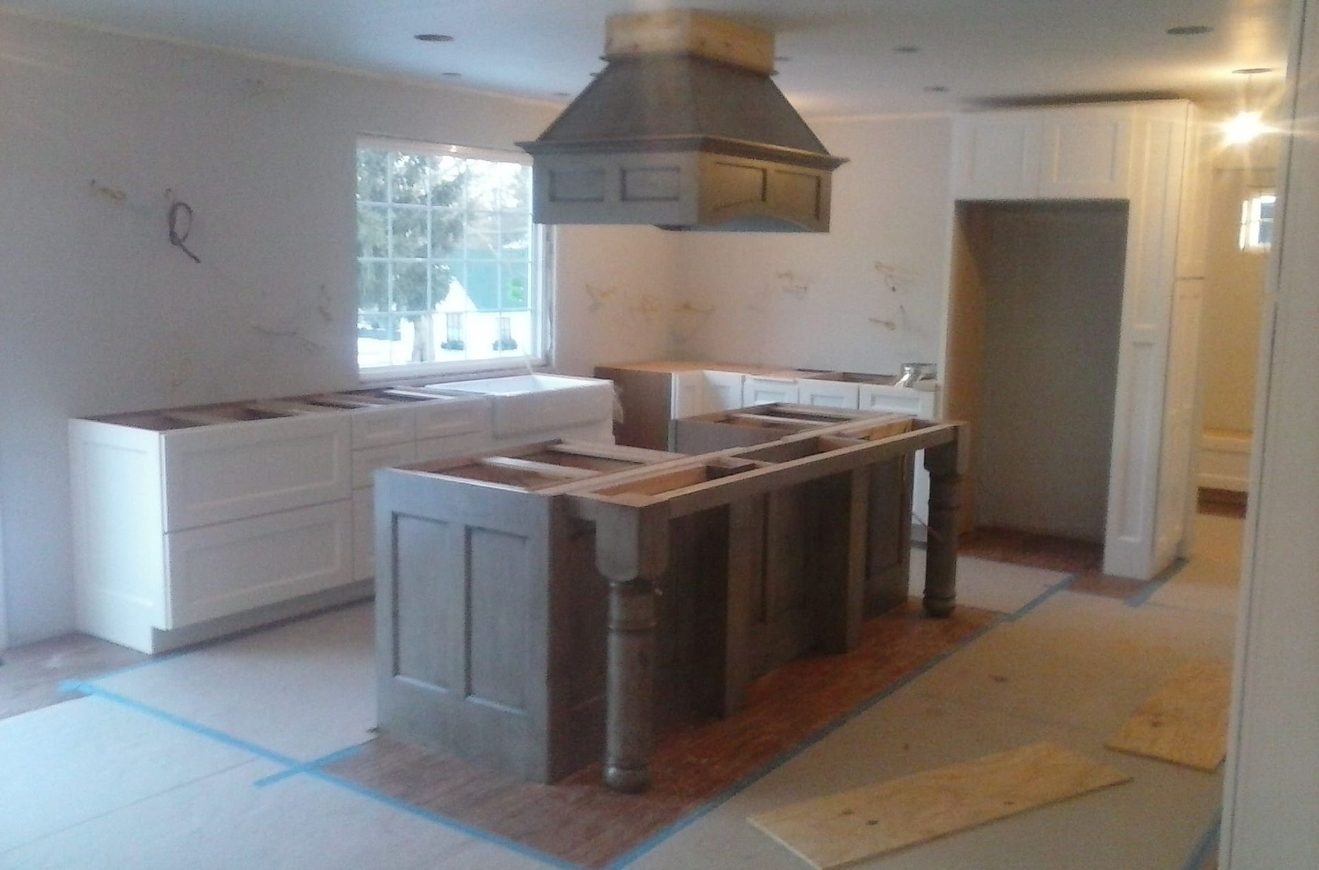 A kitchen under construction with a large island in the middle