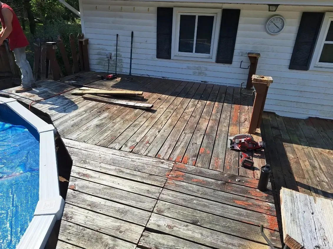 A residential deck renovation showing old wooden decking being removed and replaced with new materials by Timberland Construction