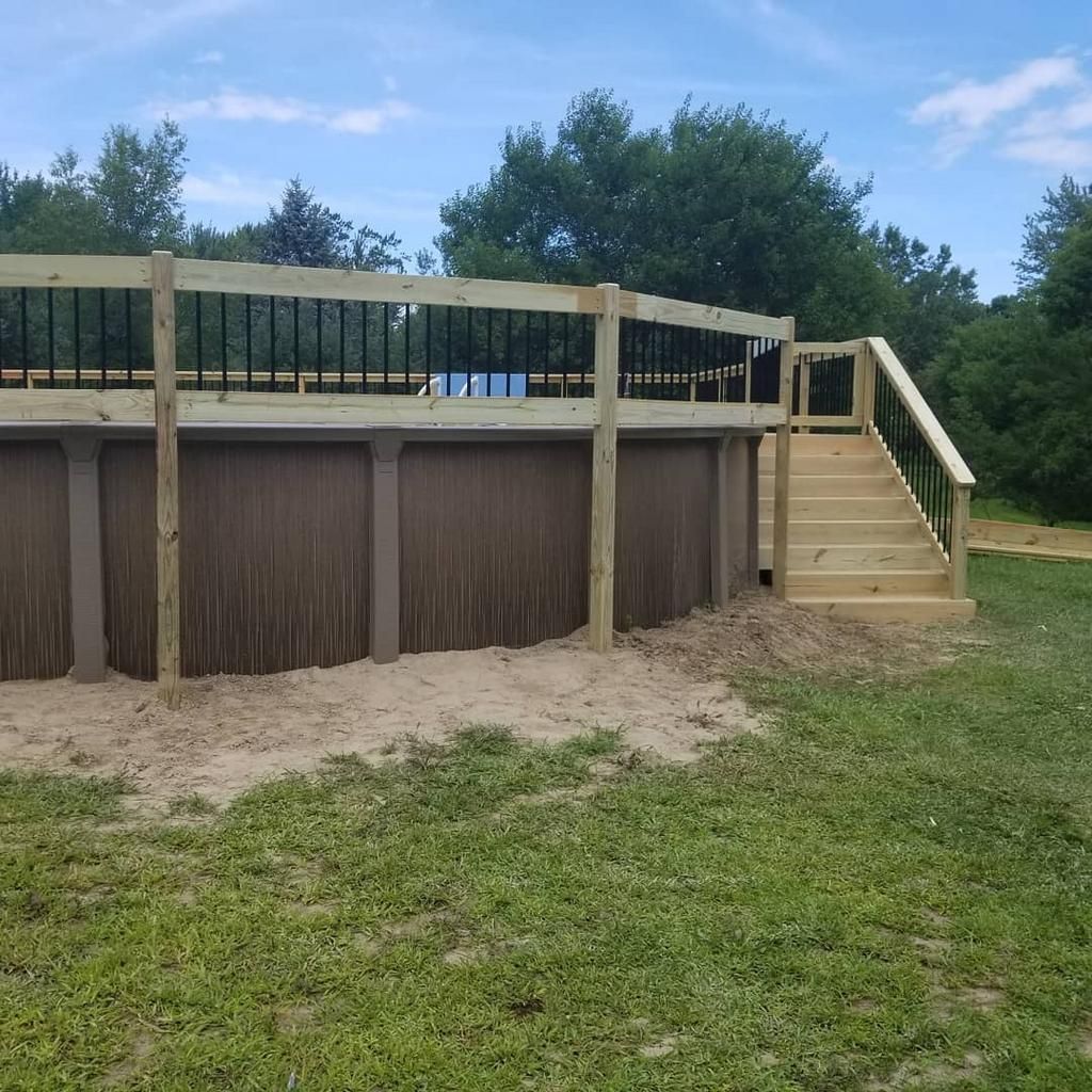 A swimming pool with a wooden deck and stairs