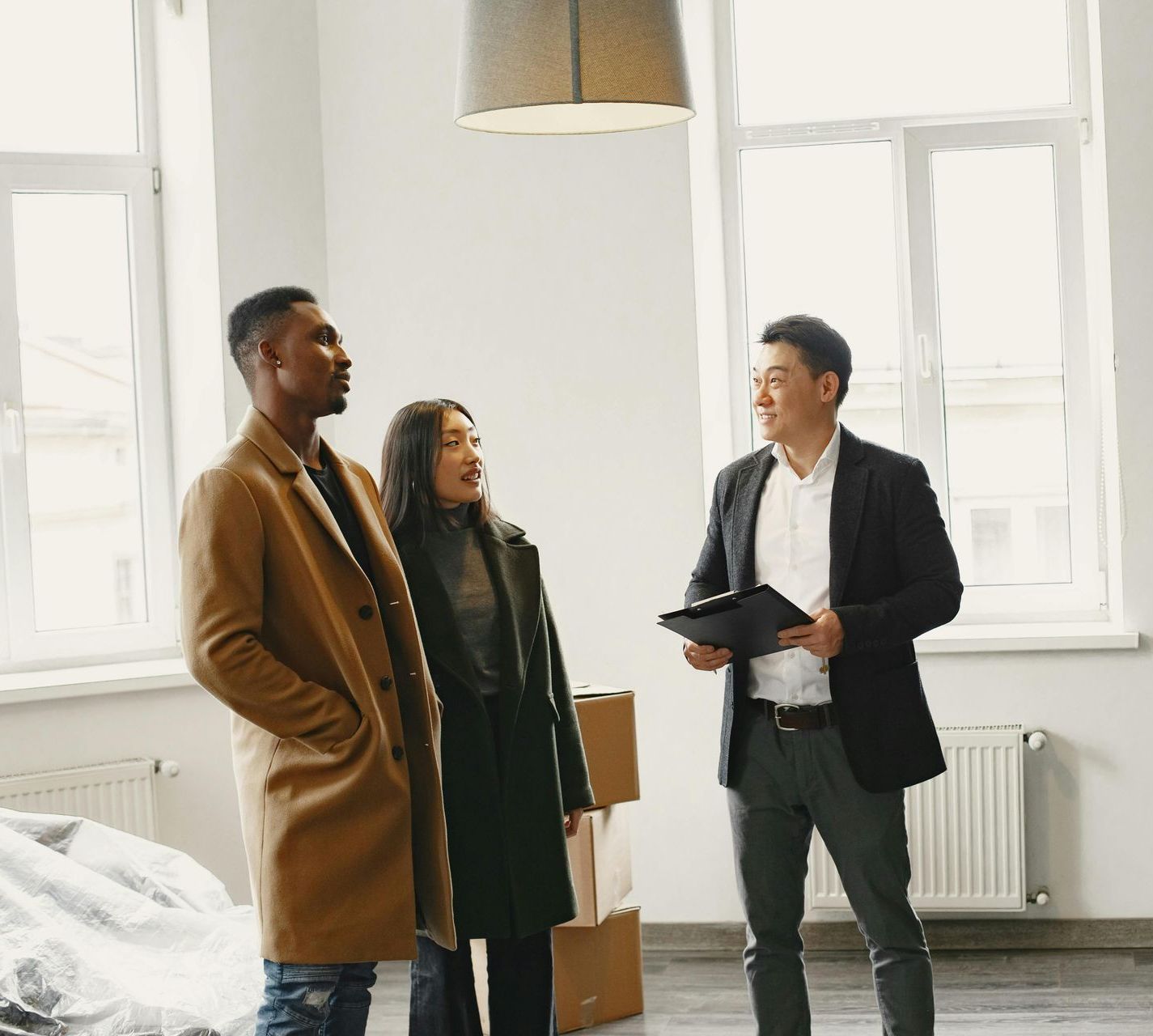A group of people are standing in a room talking to each other.