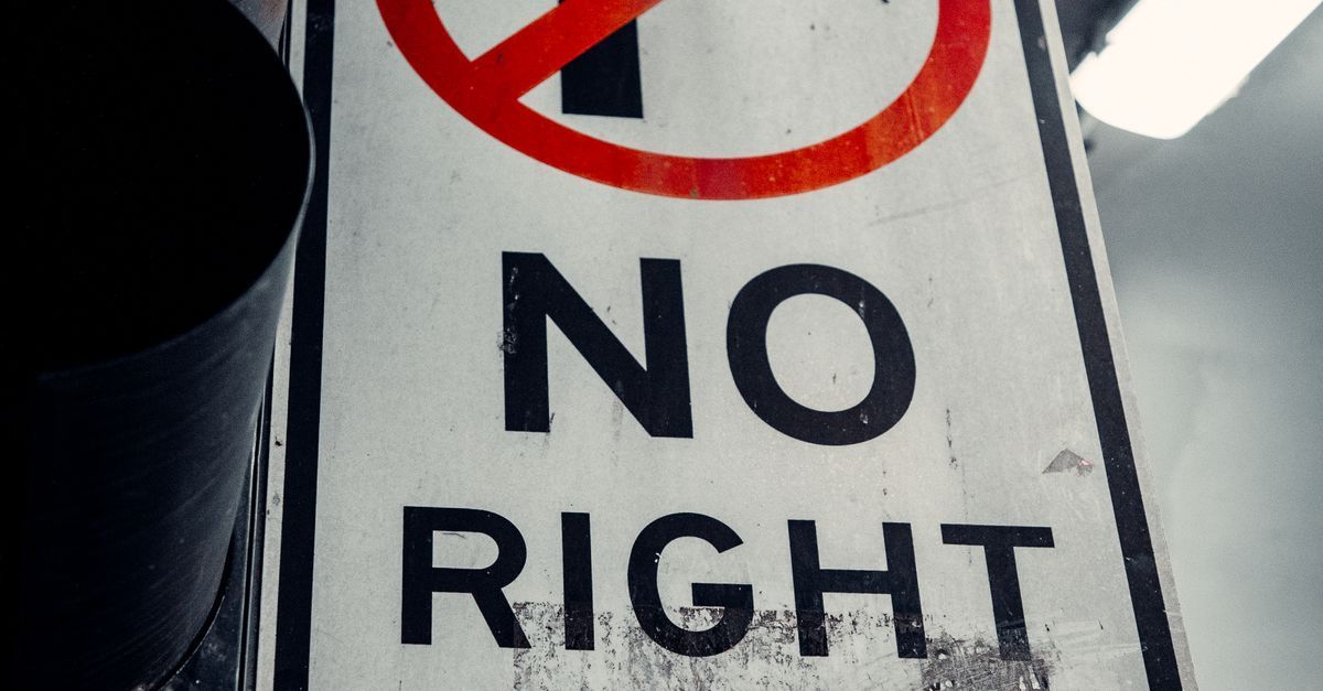 “No Right” traffic sign with a red prohibition symbol against a cloudy sky