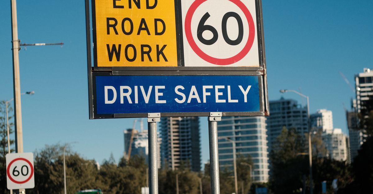 Road work sign with 60 speed limit and “Drive safely” message on a city roadside.